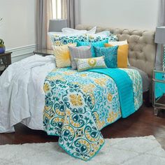 a bed with blue and yellow comforters in a bedroom