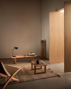 a living room filled with furniture next to a wall mounted lamp and wooden door on the side