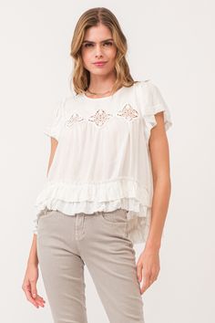 image of a female model wearing a VADA EMBROIDERY MOTIF BLOUSE WHITE DEAR JOHN DENIM White Blouse With Ruffles And Flutter Sleeves, Bohemian Broderie Anglaise Short Sleeve Blouse, Bohemian Blouse With Broderie Anglaise Short Sleeves, Casual White Lace Top With Broderie Anglaise, Casual Short Sleeve Lace Top For Spring, Summer Crew Neck Blouse With Ruffle Hem, Spring Blouse With Ruffle Hem And Crew Neck, White Bohemian Top With Ruffles, Casual Cotton Tops With Cutwork Hem