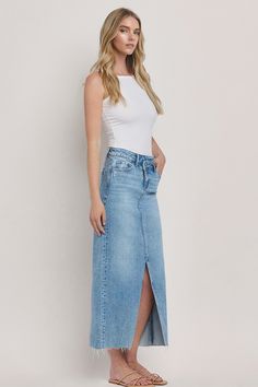 Maxi denim skirt. Asymmetrical waistline with front slit detail. Raw hem. Zipper and button closure. Materials: 99% Cotton, 1% Spandex. Sizing: Small: US Size 0-2 Medium: US Size 4-6 Large: US Size 8-10 Maxi Denim Skirt, Skirt Asymmetrical, Heel Accessories, Outfit Wedding Guest, All White Outfit, Denim Maxi Skirt, Sweater Tank Top, Glamour Fashion, White Outfits