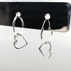 Add a touch of timeless sophistication to your jewelry collection with our exquisite 925 Sterling Silver Heart Hoop Earrings. Crafted with precision and love, these earrings feature a beautifully delicate design measuring 15/32 inches in width and 25/32 inches in length, perfectly capturing the essence of minimalist elegance. Stamped with the 925 hallmark, these heart hoop earrings guarantee the highest quality of sterling silver, ensuring they remain a cherished piece for years to come. Made for both everyday wear and special occasions, these sterling silver heart hoops are incredibly versatile. Whether you're dressing up for a romantic dinner or adding a subtle sparkle to your casual outfit, these earrings will effortlessly elevate your look. The secure clasp ensures they stay in place, Silver Hoop Earrings With Heart Charm For Anniversary, Sterling Silver Double Heart Hoop Earrings For Gifts, Sterling Silver Hoop Earrings For Valentine's Day, Nickel-free Double Heart Sterling Silver Hoop Earrings, Silver Small Hoop Heart Earrings For Anniversary, Sterling Silver Hoop Jewelry For Valentine's Day, Dangle Hoop Earrings For Valentine's Day Anniversary, Dangle Hoop Earrings For Anniversary And Valentine's Day, Valentine's Day Sterling Silver Hoop Jewelry