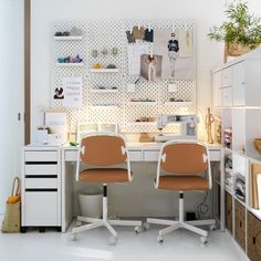 two office chairs sitting next to each other in front of a desk with pictures on the wall