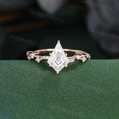 an engagement ring with a princess cut diamond in the center and three small diamonds on each side