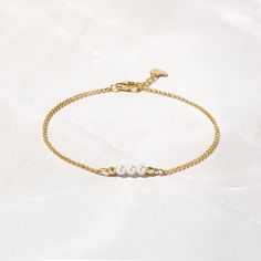 A graceful, timeless bracelet with three exquisite pearls! Stack this piece with other bracelets, or wear it alone for a minimalist, yet sophisticated style. The perfect bridesmaids gift too! 14K Gold Plated over Sterling Silver Nickel-free & hypoallergenic Made of highest quality imitation pearls for an authentic look Pearl size: 3.5mm Lobster clasp closure with 0.5" extension Minimalist Pearl Jewelry With Oyster Bracelet, Minimalist Oyster Bracelet Jewelry For Wedding, Minimalist Wedding Jewelry With Oyster Bracelet, Classic Pearl Bracelets With Adjustable Chain, Minimalist Gold Pearl Bracelet With Delicate Chain, White Minimalist Bracelets For Anniversary, Minimalist White Bracelets For Anniversary, Minimalist Pearl Bracelet With Adjustable Chain, Adjustable Minimalist Pearl Bracelet