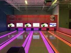 a bowling alley with neon lights on the floor