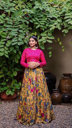 Mustard Yellow soft silk printed lehenga set comes with closed neck bandhani blouse in pink color which features full sleeves and closed back with hook-eye opening. Color of Lehenga - Mustard Yellow. Color of Crop Top - Pink. Fabric of Lehenga- Printed Soft Silk. Fabric of Crop Top - Modal Silk. Number of components - 2. Measurements in the size chart are all garment measurements. The actual print-placement of the product may vary slightly from the image shown. Standard Lehenga Length - 43". Sta Pink Anarkali Set With Kalamkari Print, Pink Semi-stitched Block Print Traditional Wear, Pink Kalamkari Print Sets For Festive Occasions, Silk Block Print Long Sleeve Sets, Pink Kalamkari Traditional Wear For Navratri, Festive Pink Kalamkari Print Sets, Pink Block Print Blouse Piece For Festivals, Unstitched Choli With Block Print For Festivals, Unstitched Block Print Choli For Festivals