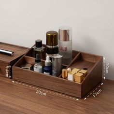 an open wooden box containing cosmetics and personal care items on a wood table with measurements