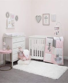 a baby's nursery with pink and gray decor, including a crib bedding set