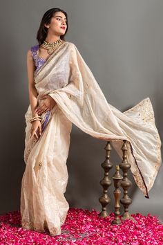 White and gold saree highlighted by zardozi embroidered abstract motifs with placed peacock motifs. Comes with blouse.
Components: 2
Pattern: Embroidered
Type Of Work: Zardozi, Sequin 
Neckline: V-neck
Sleeve Type: Sleeveless
Fabric: Tissue
Color: White,Gold
Other Details: 
Contrast saree piping
Closure: Blouse: Back placket
Occasion: Sangeet,Wedding - Aza Fashions Jimmy Choo Saree, White And Gold Saree, Contrast Saree, Gold Saree, Peacock Motifs, Abstract Motifs, Georgette Blouse, Heavy Embroidery, Pearl Cream