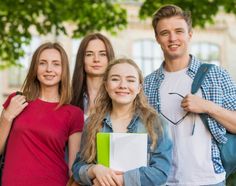 group of young people posing for the camera with backpacks and books in their hands