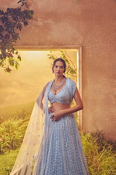 Featuring a sky blue tulle lehenga embroidered fully by hand with various tonal ornamental sequences and tonal Japanese bugle beads. It is paired with a cutwork dupatta and a stylised blouse .From Aneesh Agarwaal's Ellora collection.DELIVERY TIMEPlease allow 8-12 weeks for your outfit to arrive.FABRIC DETAILSNetProfessional cleaning only. Tulle Lehenga, Blue Tulle, A Sky, Change Image, Bugle Beads, 12 Weeks, Cut Work, Body Measurements, Skirt Length