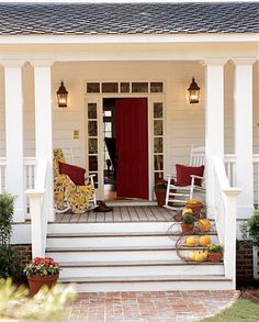 the front porch is decorated with pumpkins and other decorations