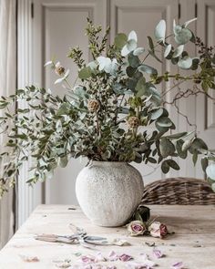 a vase filled with flowers sitting on top of a table next to scissors and other items