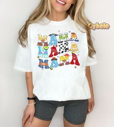 a woman wearing shorts and a t - shirt with the word mama spelled in colorful letters