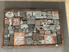 an old wooden box filled with lots of different metal items on top of a table