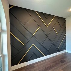 an empty room with wood flooring and black wallpaper