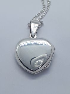 Stunning Heart Locket Sterling Silver Necklace. This beautiful pendant has been made in solid 925 sterling silver. This pendant will make a beautiful any occasion gift. Sterling silver chain is also included in the price. Pendant will be shipped to you in an elegant gift box. A tracking shipping number will be provided to you once necklace has been mailed. Locket  Pendent Measurements: 1.00 x 0.60 inches Sterling Silver Chain:  20 inches Materials: 925 Sterling Silver  Weight: 5.3 Gram Thanks fo Silver Pendent, Pendant With Chain, Heart Locket, Chain Pendant, Locket Necklace, Elegant Gift, Sterling Silber, Solid 925 Sterling Silver, Sterling Silver Chains