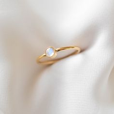 A simple gold ring featuring a genuine moonstone (4mm in diameter). The natural blue flash of the moonstone is visible depending on the light and angle. This ring is 14k gold filled and is hypoallergenic, water-resistant, and tarnish-resistant. --------------------♥ PROMOS ♥-------------------- Want 10% off? Join the mailing list by visiting http://bit.ly/vedern . --------------------♥ BUY WITH CONFIDENCE ♥-------------------- Don't love it? Message me to set up a return or exchange. If you find Adjustable 14k Yellow Gold Moonstone Ring, Adjustable Minimalist Stackable Round Cut Rings, Delicate Adjustable Moonstone Ring, Gold Delicate Moonstone Ring, Gold Dainty Opal Ring Birthstone, Delicate Gold Moonstone Ring, 14k Gold Moonstone Promise Ring, Delicate 14k Gold Moonstone Ring, White Dainty Crystal Ring With Round Cut