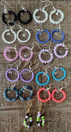 several pairs of earrings are shown on the floor with beaded hoops hanging from them