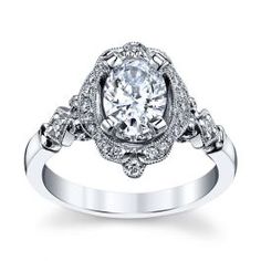 a white gold ring with an oval diamond center surrounded by small round diamonds on the band