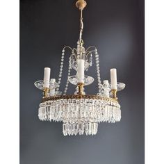 a chandelier hanging from the ceiling in a room with grey walls and flooring