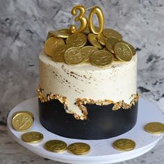 a cake decorated with gold coins and the number twenty on top is sitting on a plate