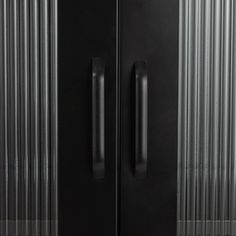 a black double door refrigerator freezer sitting on top of a floor next to a wall