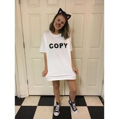 a girl in a white t - shirt with the word copy printed on it, standing next to a black and white checkered floor