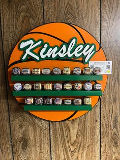 a basketball with the name kinsley on it hanging from a wall next to a pair of scissors