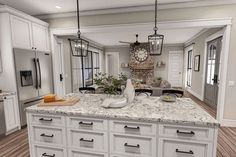 a large kitchen with white cabinets and marble counter tops