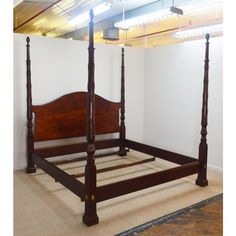 a bed with four posts in an empty room