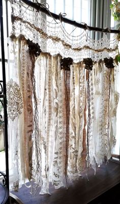 an old window curtain with lace hanging from it