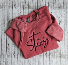 This listing is for a Heather sport scarlett red colored sweatshirt with She is Strong embroidered on it. This is NOT a heat press design. This is machine embroidered with thread. Red Cotton Hoodie With Embroidered Graphics, Red Hoodie With Embroidered Logo And Crew Neck, Red Casual Sweatshirt With Custom Embroidery, Red Sweatshirt With Letter Embroidery For Winter, Red Letter Embroidery Sweatshirt For Winter, Red Crew Neck Sweatshirt With Embroidered Graphics, Red Embroidered Sweatshirt For Fall, Red Sweatshirt With Custom Embroidery For Fall, Red Long Sleeve Sweatshirt With Embroidered Graphics