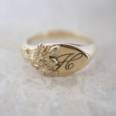 This vintage-inspired floral ring is a row of dainty flowers wrapped around your fingers. Handmade and polished, it is available in solid 8K and 14K gold. This item is engravable with text or monogram of your choice at no extra cost. The initals are engraved onto the ring and embedded in the 3D model for a flawless embossed finish. It is also possible to add a diamond or birthstone or diamond to this ring at an additional fee. Please inquire for details. A few notes about our gold: - Though we d Heirloom Birth Flower Jewelry, Heirloom Birth Flower Jewelry For Anniversary, Heirloom 14k Gold Engraved Flower Ring, Classic 14k Gold Flower Ring For Formal Occasions, Vintage Birth Flower Rings For Anniversary, Elegant Engraved Open Flower Ring, Heirloom Engraved 14k Gold Flower Ring, Classic Wedding Jewelry With Birth Flower, Heirloom Oval Flower Ring Hallmarked