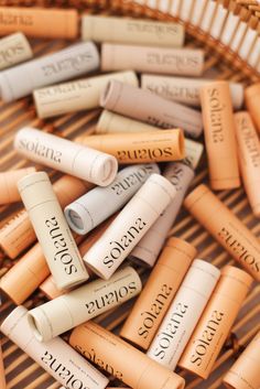 many different types of lip bales sitting in a wicker basket on the floor