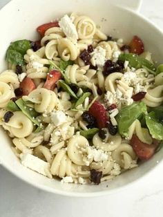 a white bowl filled with pasta salad on top of a table