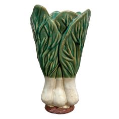 a green and white vase sitting on top of a table