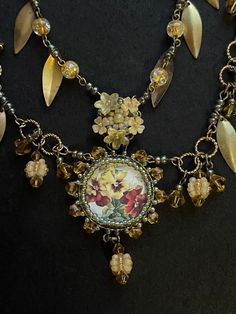 the necklace has flowers and leaves on it