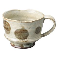 a white cup with brown spots on it