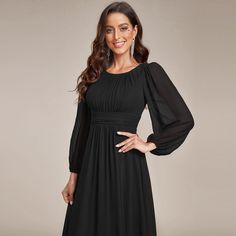 a woman wearing a long black dress with sleeves on the shoulders and an open neckline