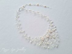 A truly beautiful bridal necklace, handmade with quality ivory freshwater pearls and the finest quality crystals set on a silver plated wire showing intricate detailing. The length is around 40cm with an extension chain to lengthen if you please. The drop on the necklace at its widest point is around 5.5-6 cm. All of our items are made to order so adjustments can be made with regards to materials and designs. Please message us if you require different specifications.  The design is handmade feat Delicate Beaded Pearl Necklace For Wedding, Delicate Pearl Beaded Necklaces For Wedding, Delicate Pearl Beaded Necklace For Wedding, Delicate Pearl Chain Beaded Necklace For Wedding, Pearl White Beaded Necklaces With Pearl Drop For Wedding, Pearl White Beaded Necklace With Pearl Drop For Wedding, Wedding Beaded Necklace With Pearl Charm, Delicate Beaded Necklaces For Wedding, Delicate Pearl Necklace For Wedding