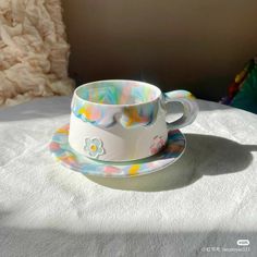 a cup and saucer sitting on top of a white tablecloth covered table cloth