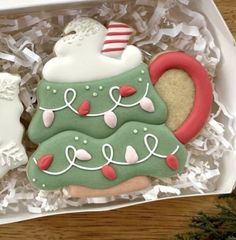 two decorated cookies in a box on a table