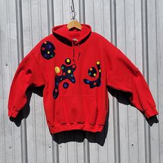 a red sweatshirt with an image of a dog on it hanging from a clothes line