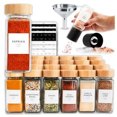 various spices and seasonings are arranged in glass jars on a white background, including pepper grinder