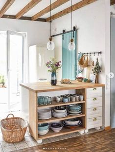 a kitchen island with plates and bowls on it in front of an open door that leads to a patio