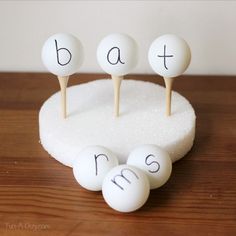 three white eggs sitting on top of a table next to each other with the word bath spelled