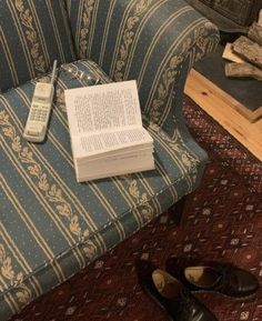 a pair of shoes and a book are sitting on the floor in front of a couch