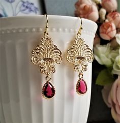 Gorgeous earrings feature gold plated brass Baroque lace filigree and faceted ruby glass drop encased in golden frame. On gold plated brass earwires These earrings are elegant and lovely for any occasion! MEASUREMENTS: Earring length: 50 mm Drop size: 40 mm Ruby drop size: (including loop): 8 X 14 mm For matching earrings, please click to this link: https://www.etsy.com/hk-en/listing/1128095371/ Purchase over $40 enjoys free shipping! Coupon code 'freeshipping1'. Free Gift Wrapping on request - Teardrop Earrings Gold, Gold Filigree Earrings, Golden Frame, Ruby Crystal, Lace Earrings, Filigree Earrings, Jewelry Bridal, Gold Filigree, Earrings Wedding