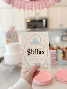 a person holding up a birthday card with the word stella's on it